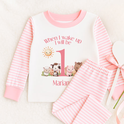 a baby girl's first birthday outfit with pink and white stripes